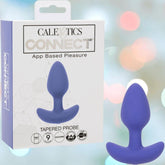 A purple silicone CalExotics Connect Tapered Probe App Controlled Anal Vibrator is shown by its box, which displays product icons and a hexagonal pattern on a soft, colorful bokeh background.